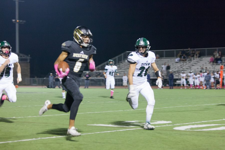 C.J. Franklin (12) runs a 40-yard touchdown pass to take the lead 21-7 in the third quarter of the Homecoming game, Oct. 13.  This was the Wolverines’ first overtime game and their second time ever beating Poway.