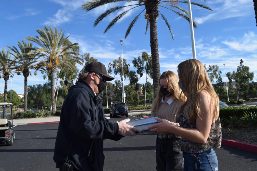 From left to right: Katelyn Jensen (9) and Amelia Jensen (11) receive textbooks Jan. 28. Westview is currently unlikely to reopen to those who opted to return due to complications with the CDPH guidelines. Photo courtesy of Emily Halim.