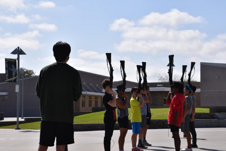 Jason Heflinger (12), left, leads the Armed Exhibition team as they practice the order toss sequence, a drill routine that involves throwing and catching rifles, May 6. Photo by Alice Chen.