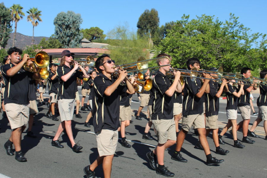 The trombone section preps their horns to play a cadence of the Patriotic Parade Sequence. Drumline queues the band throughout the march to indicate when to play. 