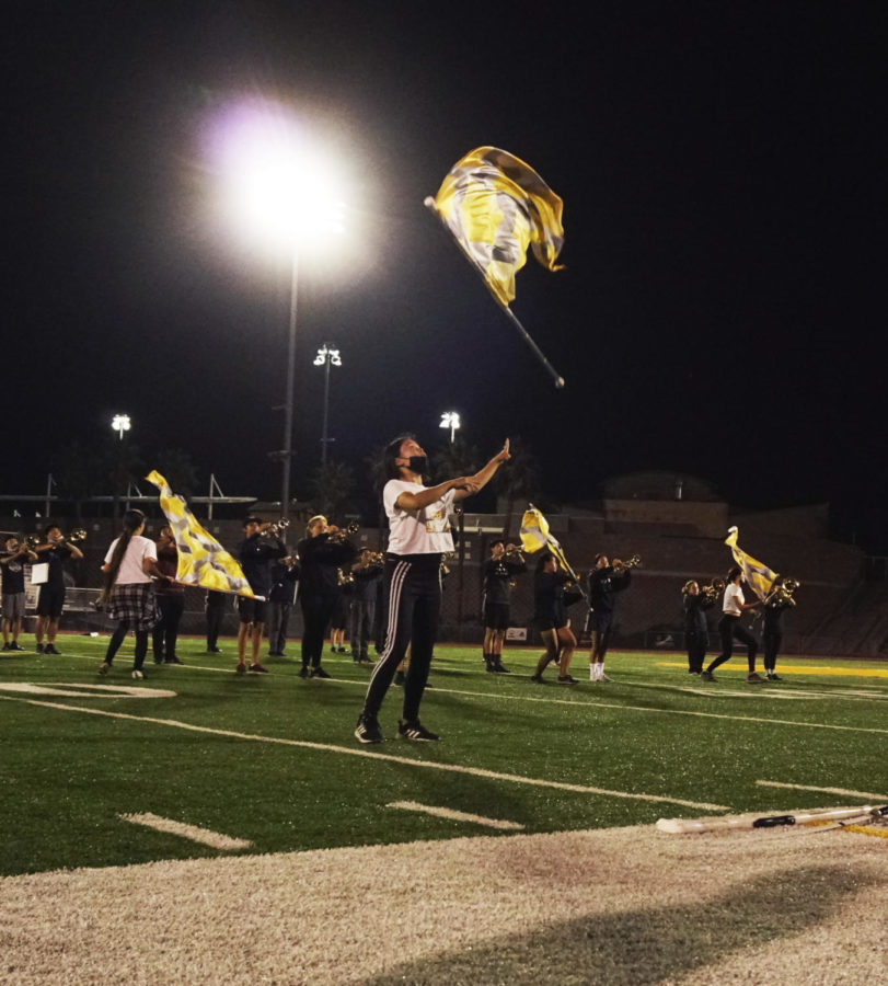 Tiffany Way (12) tosses her flag during a practice run of GOLDs show, Sept. 28. Photo by Byron Tran.