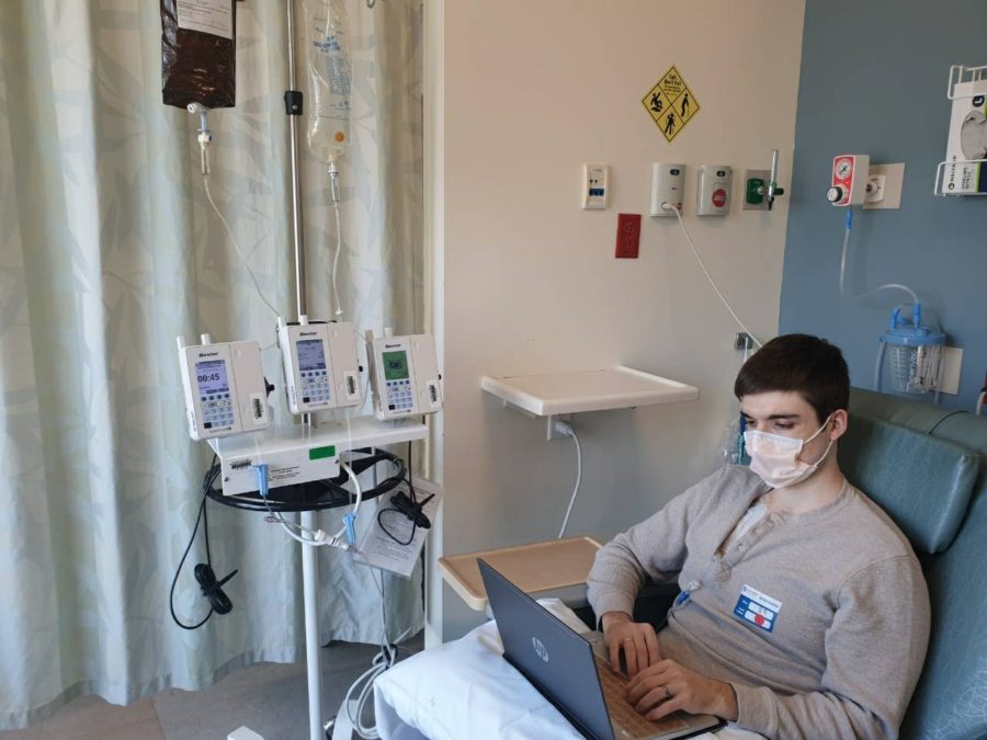 Sam Bozoukov does schoolwork at the hospital, while receiving chemotherapy. Since his diagnosis, he has balanced personal and professional responsibilities so that he is adequately prepared for his daughters birth. 