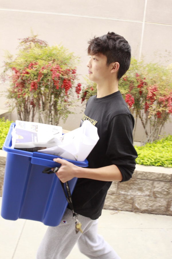 Josh Yang (10) lifts a bin of recyclable papers into a recycling dumpster. He and other ASB members volunteer to do this every Friday in order to grow the new ASB-led recycling program.