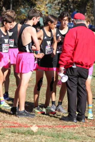 Ryland Arciaga (12) discusses strategies with teammates at League Finals, Nov. 3. These pre-race talks help to calm the runners’ anxiety for the run.