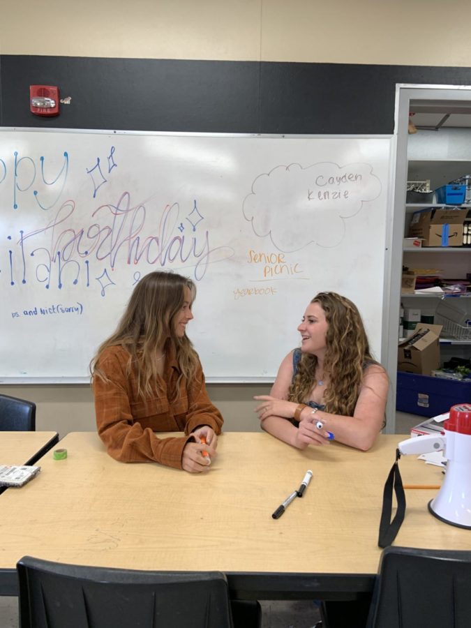 Lily Bryan (12) and Lucy Sullivan (12) discuss the details of the senior picnic, May 31. The picnic will be held May 7, in the amphitheater. Photo by Amy Wang.