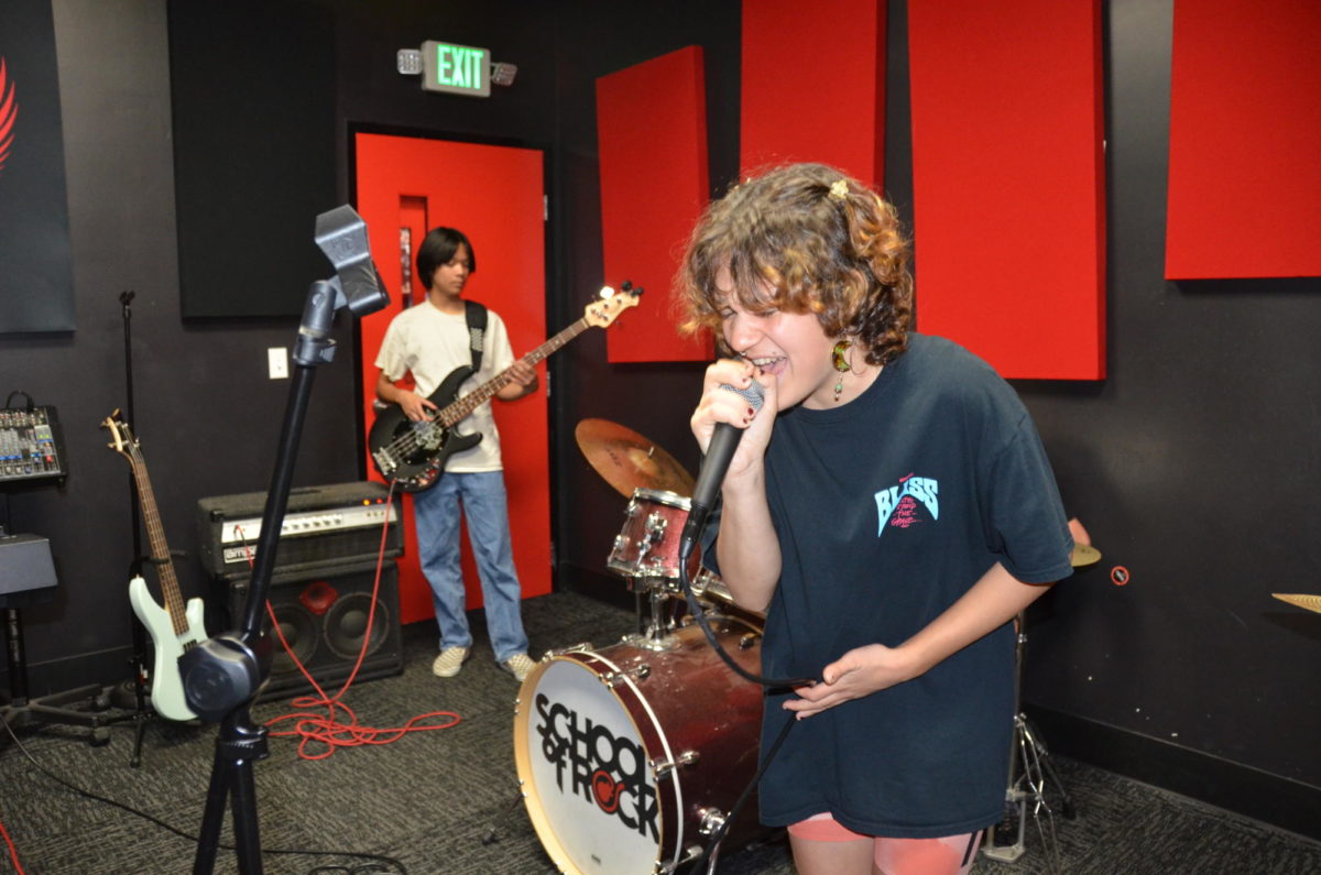 Jamie Fusaro-Mobley (12) sings Sunburn by Muse in the School of Rock practice studio, Aug. 17. Music is a shared passion for their family and one that Fusaro-Mobley wishes to continue pursuing with their band.