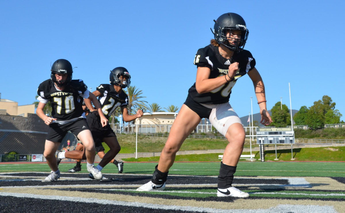 Ava Muylle (11) practices an offensive drill along with fellow teammates, Sept. 7. Muylle, in her first year on the team, is the only girl in all of Wolverine football, switching between playing on the offensive and defensive lines. 