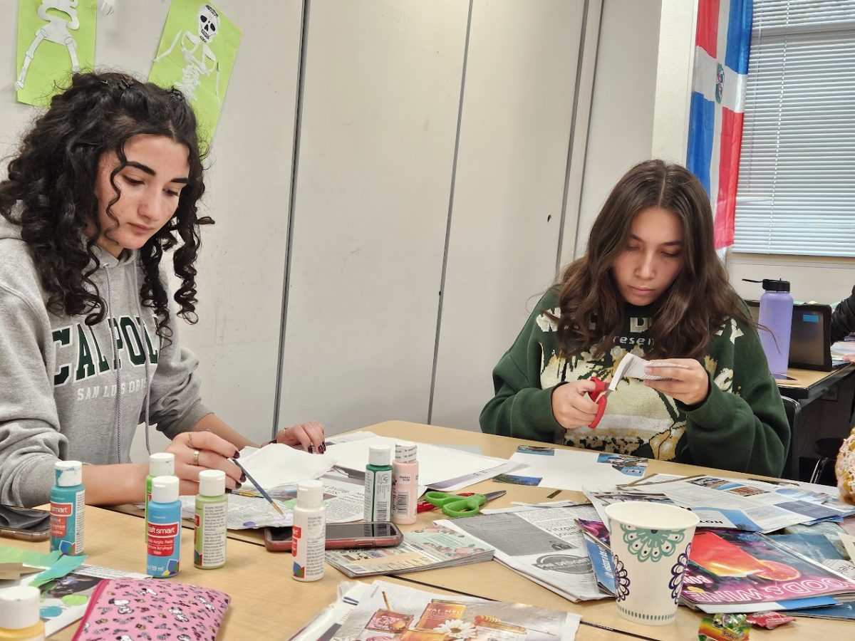 Donna Mahmoudi (12) and Aleyna Pala (12) construct inspirational posters out of magazines, newspapers, and paints in their Spanish 9-10 class, Nov. 7. The posters will be used to decorate the classroom, each students art contributing. 