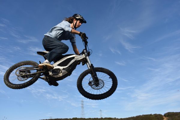 Jake Scarbel (11) jumps over a dirt hill on a trail in the Peñasquitos Canyon on his Surron bike, March 5. He started mountain biking nearly 10 years ago before transitioning to his current motorcycle-e-bike hybrid that he customizes and repairs himself.
