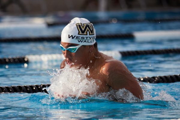 Derek Ho (9) competes in the 100-yard breaststroke race at home against Poway, March 15. As one of the fastest on the team, Ho placed first with a time of 59:35. 