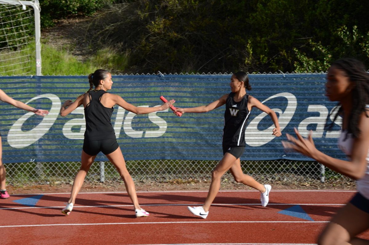 Jordyn Vales (9) passes the baton to Kaitlyn Arciaga (10) to finish the second leg of the 4x400 relay, March 23. The team ended the relay with a time of 3.58.