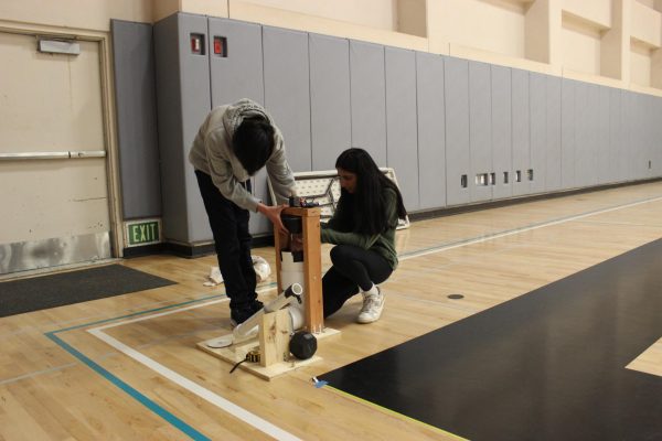 Ryan Bui (11) and Shayna Mehta (11) reset their Air Trajectory launchers weight system during one of their practices, March 30. As a weight drops down, a ping-pong ball is launched out of the PVC pipe, which hits a target two to eight meters away.