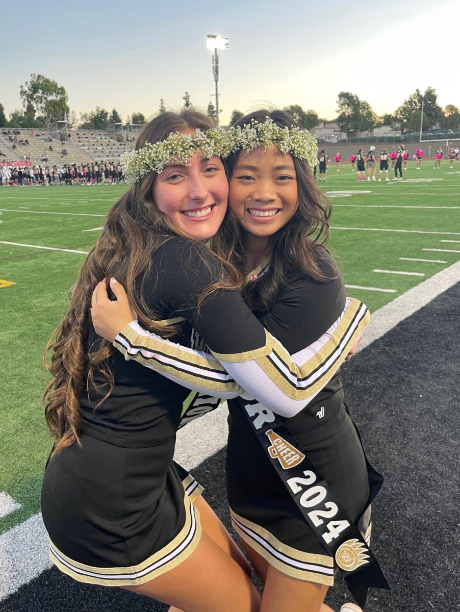 Kuo and Shetzer pose for a photo together after cheer senior night, Oct. 5. Courtesy of Marcella Lee