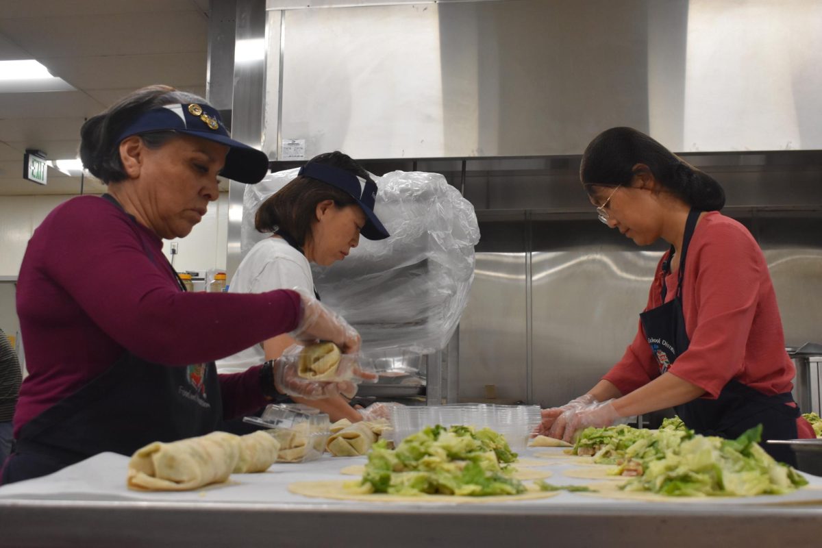 Mercedes Briggs, a level three FNA (left), Jennifer Nguyen, a level two FNA (middle), and Yan Zhao (right), a level one FNA, assemble chicken ceasar wraps, Oct. 4. They utilized the school's main kitchen.