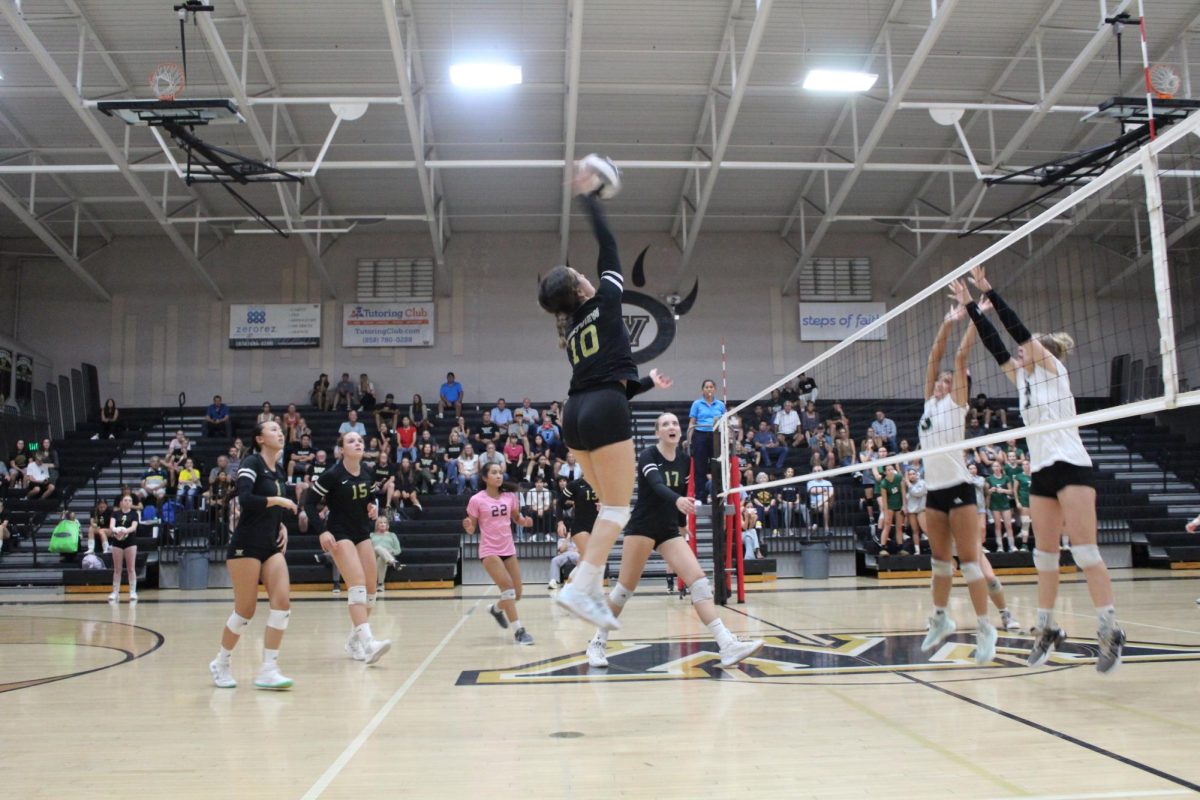 Ava Zamora (12) jumps to hit the ball in the game against Poway High School, Oct. 3 Despite a slow beginning, the team managed to win three consecutive sets.