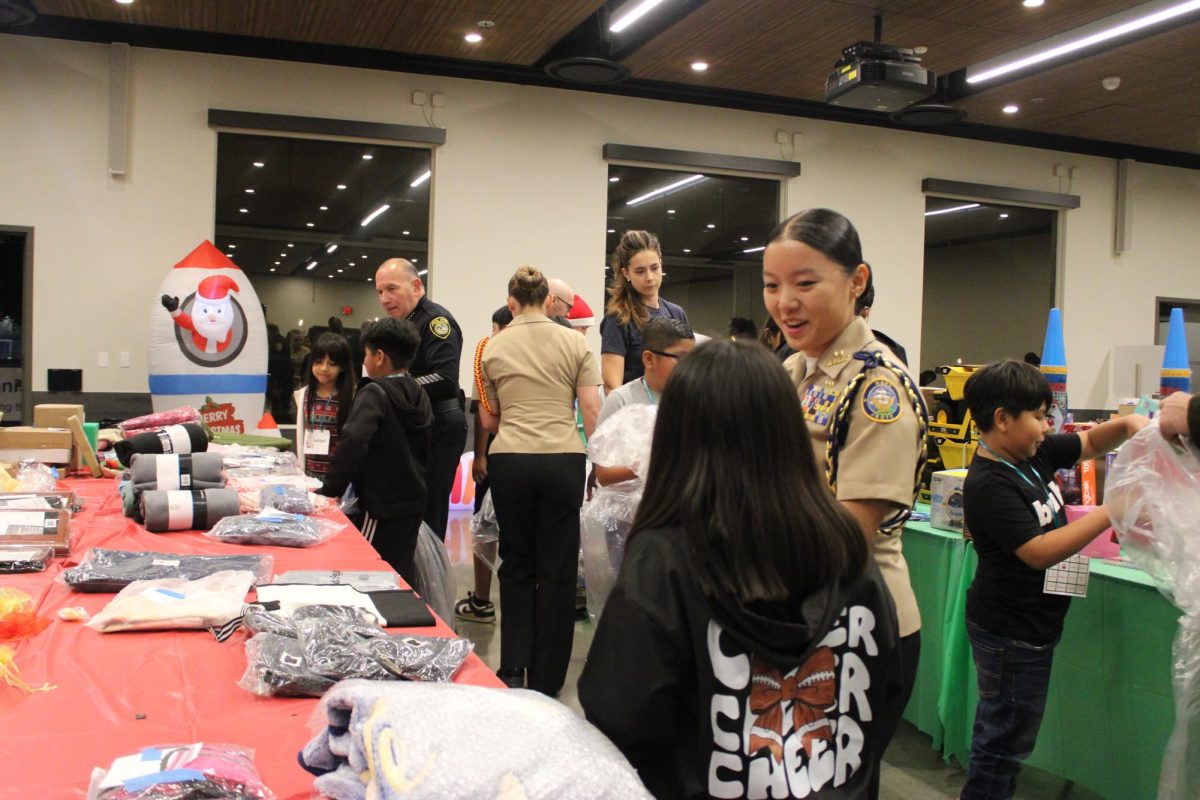 Alison Hauw (12), helps her buddy at the Poway Community Center select a gift for her family, Dec. 5. At the end of the event, NJROTC cadets picked out surprise presents for their buddies.