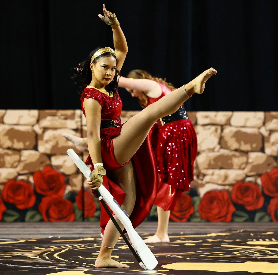 Serenity Calica (12) fan kicks over her rifle at the 2025 Winter Guard Association of Southern California competition, April 13. Color Guard's performance theme this year was based on tarot cards. 