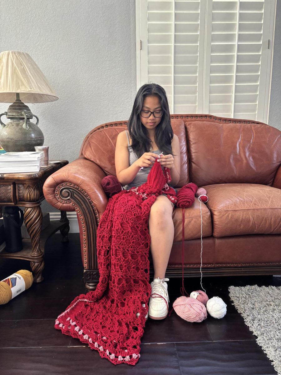 Zoey Espiritu (11) crochets her Prom dress on her couch. She has been crocheting for three years, making clothing such as cardigans and sweaters