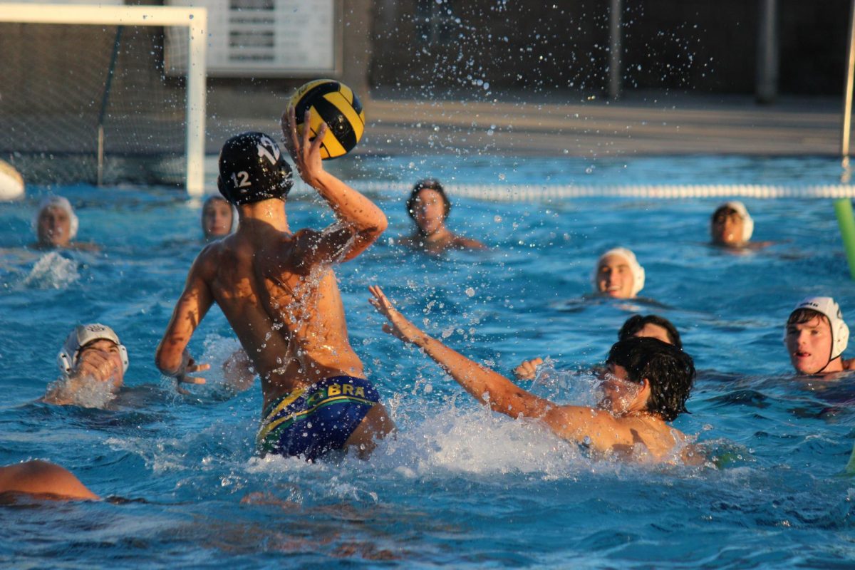 Philip Zajac (11) take a shot against the football team during the first half, Sept. 30. The girls water polo team organized the fundraiser against football, raising $391 for equipment. 