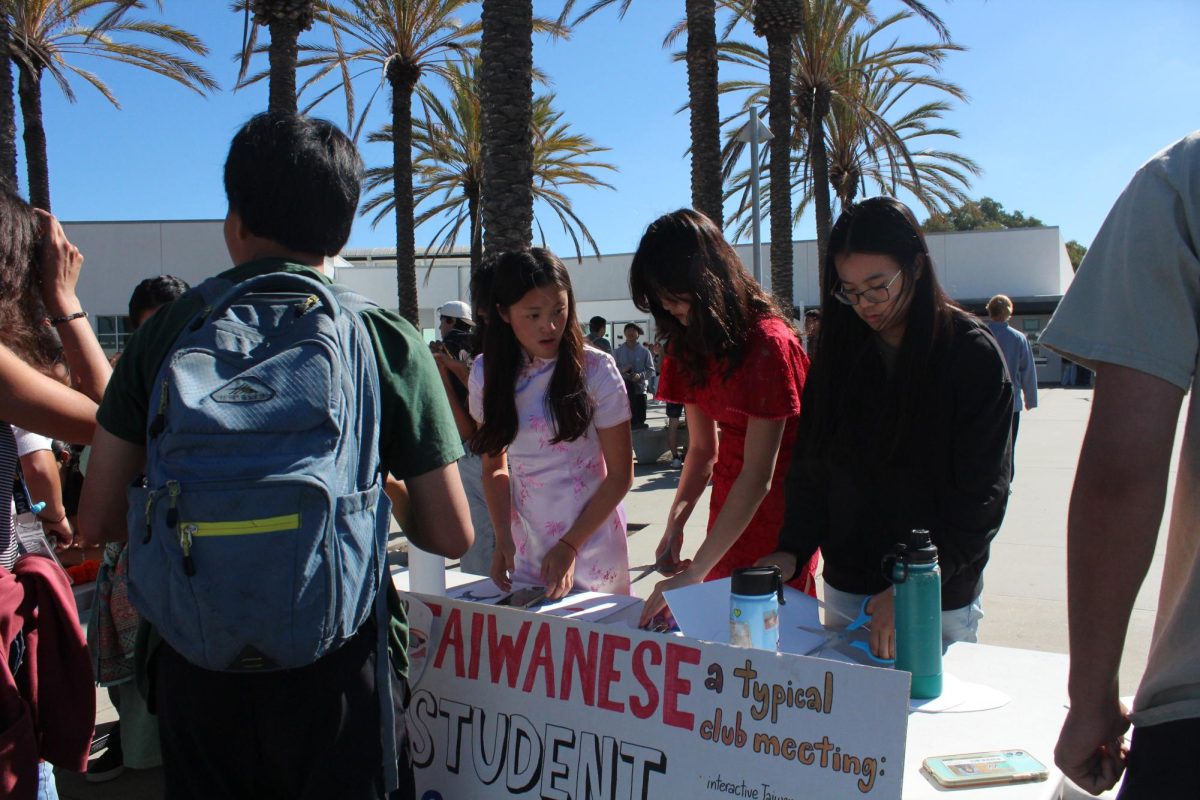 Cynthia Chang (11), Isabella Chung (10), and Joyce Chen (11) prepare Peking opera masks for students to decorate.