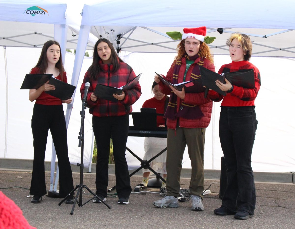 Leeann Terral (8), Nicole Pawlicki (12), Dain Monahan (11), and Eileen Terral (11) {left to right] carol at the Rancho Penasquitos "Cookies and Cocoa" event, Saturday. The performance was one of the clubs' first community appearance. 