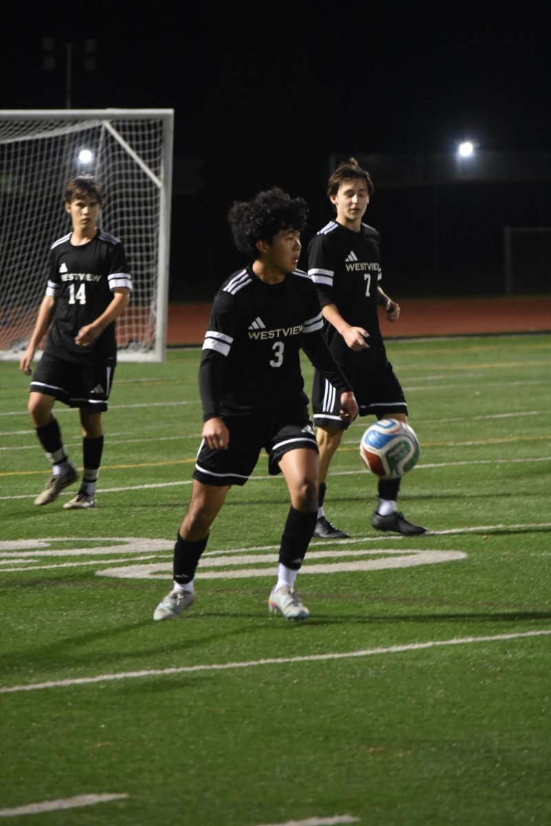 Outside back Tyler Woolridge (12) scans the field for an open teammate during the Senior Night game, Feb. 4. The team conceded a goal, but quickly made a comeback with goals from Brayden Rojas (11) and Jayden Williams (12).

Courtesy of Lyla Jeon
