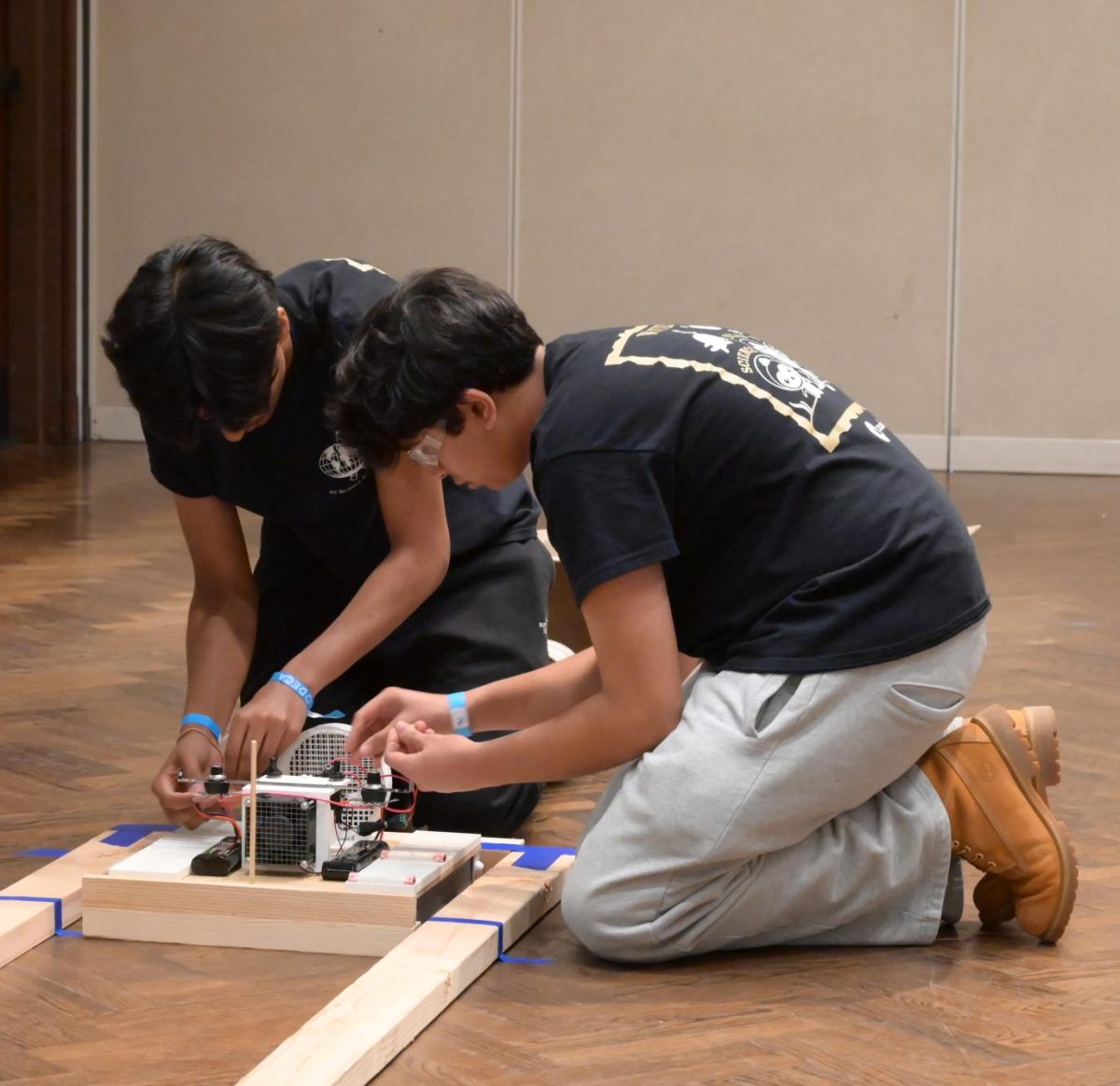 Avi Patel (10) [left] and Sanchay Koppa (11) [right] adjust the voltage of their hovercraft, Feb. 28. Koppa and Patel won fifth place in the hovercraft event.