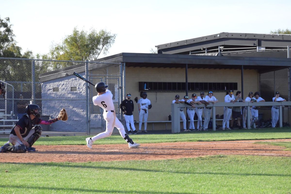 Devin Martinez (11) hits the ball before running to first base, March 23. After a slow start, the Wolverines took control in the fifth inning and won, bringing them to a seven-game streak.
